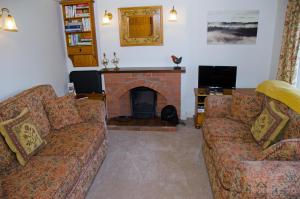 a living room with two couches and a fireplace at 1 Hope Cottage in Spilsby