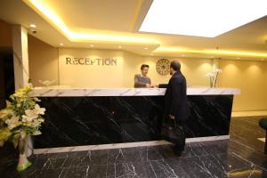 a man and a woman standing at a reception desk at kocatepe hotel in Ankara