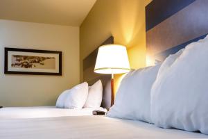 A bed or beds in a room at Welcome Suites - Minot, ND