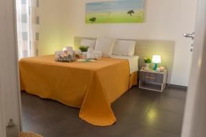 a bedroom with a bed with a orange table cloth at MareinSicilia Dammusa Residence in Scicli