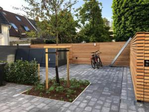 un vélo garé à côté d'une clôture avec un arbre dans l'établissement meerZEIT Norderney, à Norderney