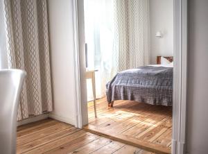 a bedroom with a bed and a wooden floor at Pension Absolut Berlin in Berlin