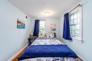 a bedroom with a bed and two windows at HI Hyannis Hostel in Hyannis