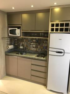 cocina con nevera blanca y microondas en Estudio moderno com linda vista para a Serra en Curitiba