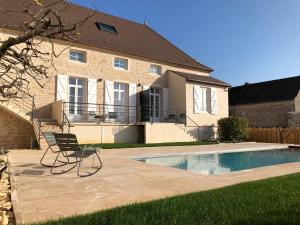 une chaise en face d'une maison avec piscine dans l'établissement La Maison Deveney Mars, à Puligny-Montrachet