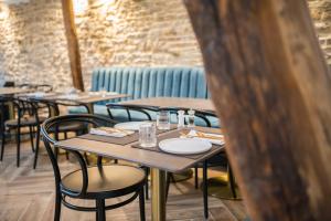 una fila de mesas y sillas en un restaurante en La Maison Deveney Mars en Puligny-Montrachet