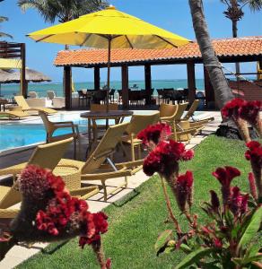 聖何塞皇冠大的住宿－Pousada Vivenda Oriente，一个带桌椅和黄色遮阳伞的游泳池