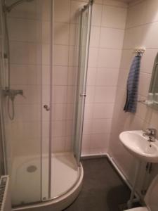 a bathroom with a shower and a sink at Hotelli Koskenniska in Forssa