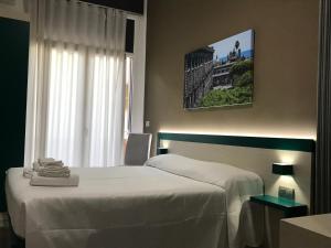 a bedroom with a white bed and a window at Guesthouse Ughetti 21 in Catania