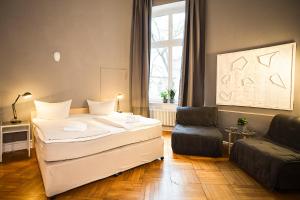 a bedroom with a bed and a couch and a window at Pension Peters – Das andere Hotel in Berlin
