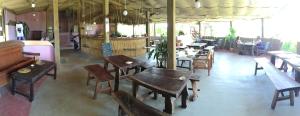 a restaurant with wooden tables and benches and tables at Nemasu Eco-lodge in Gunjur