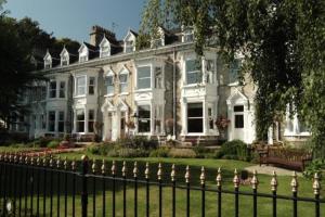 a large house with a fence in front of it at Wheatlands Lodge Hotel in York