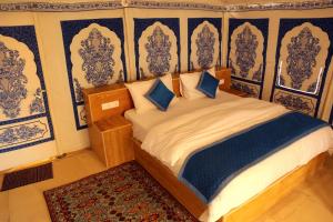 a bedroom with a bed with blue and white wallpaper at Exotic Luxury Camps in Jaisalmer