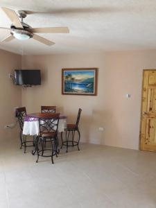 a dining room with a table and chairs and a ceiling fan at Manderley Villas in Saint Philip