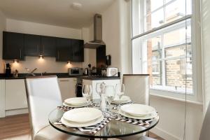 una cocina con una mesa con platos y vasos. en Braid Apartments by Mansley en Edimburgo