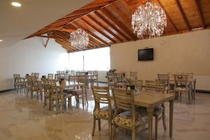 een eetkamer met tafels en stoelen en kroonluchters bij KORKMAZ OTEL in Merzifon