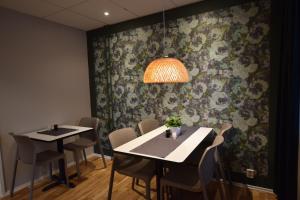 a dining room with two tables and chairs and a patterned wall at Hostel Snoozemore in Gothenburg