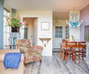 a living room with a table and chairs and a chandelier at Maison la Tulipe in Zoutelande