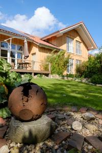 une maison avec un grand rocher en face d'une cour dans l'établissement Fewo-Mundi, à Egestorf