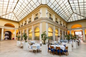 a room with tables and chairs in a building at Tergesteo Palace Suite in Trieste