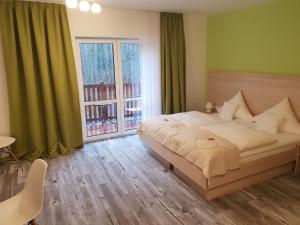 a bedroom with a bed and a large window at Neue Mühle Kleines Landhotel in Brandenburg an der Havel
