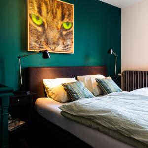 a bed with a picture of a cat with green eyes at B&B 'het Gripshuis' in Vught