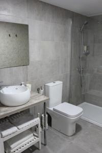 a bathroom with a sink and a toilet and a tub at Color Suites Alicante in Alicante