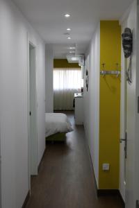 a bedroom with a bed and a yellow wall at Color Suites Alicante in Alicante