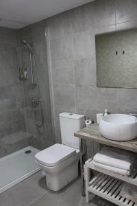 a bathroom with a toilet and a sink and a tub at Color Suites Alicante in Alicante