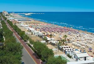a beach with a lot of umbrellas and the ocean at Hotel Vienna in Senigallia