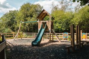 a playground with a slide and a play structure at Newby Bridge Country Caravan Park in Newby Bridge
