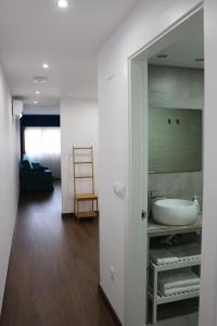 La salle de bains est pourvue d'un lavabo et d'un miroir. dans l'établissement Color Suites Alicante, à Alicante