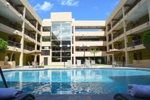 a swimming pool in front of a building at Hotel Araiza Hermosillo in Hermosillo