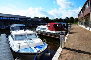two boats are docked at a dock next to a building at Tewitfield Marina in Carnforth