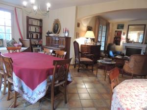 a dining room and living room with a table and chairs at Clos Sainte-Garde in Saint-Didier