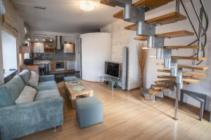 sala de estar con sofá y escalera de caracol en Luxury Vision Apartment, en Opole