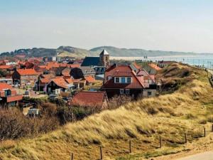 a group of houses on a hill next to the ocean at Maison la Tulipe in Zoutelande