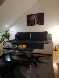 sala de estar con sofá negro y mesa en Two Kings apartment, en Novi Sad
