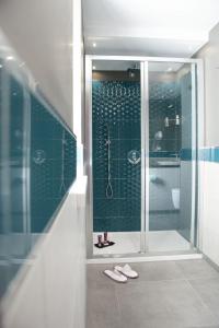 a bathroom with a shower and a pair of slippers at La Vigna Hotel in Bonea +30 photos
