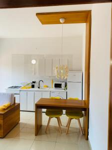 cocina con mesa de madera y 2 sillas amarillas en Nandy's home, en Odza II