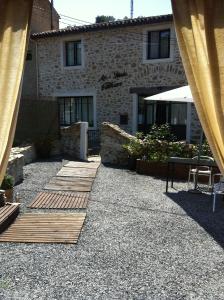 a patio with a building and a table and chairs at Au Paradis Cathare in Fraissé-des-Corbières