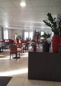 a restaurant with tables and chairs and potted plants at Doubs Hotel - Besançon Ecole Valentin in Besançon +18 photos
