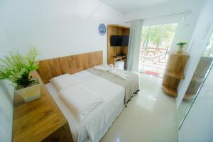 een slaapkamer met een bed en een glazen schuifdeur bij Pousada Toca dos Aventureiros in Barreirinhas
