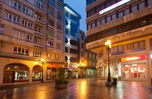 eine leere Stadtstraße in der Nacht mit Gebäuden in der Unterkunft Duerming Longoria Plaza Hotel in Oviedo