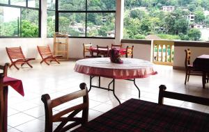 a room with a table and chairs and windows at Majestic Tourist Hotel in Kandy