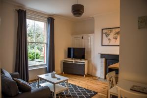 a living room with a couch and a tv and a table at Toothbrush Apartments - Central Ipswich - Fonnereau Road in Ipswich