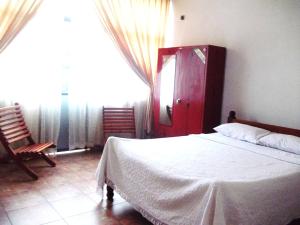 a bedroom with a white bed and a red door at Majestic Tourist Hotel in Kandy