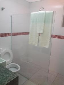 a bathroom with a shower and a toilet and towels at Motel Sky (Adults Only) in Salvador
