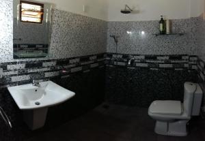 a bathroom with a sink and a toilet and a mirror at Happy Spring Guest in Mirissa