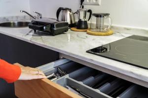 a person reaching into a drawer in a kitchen at Furnas Lake Forest Living in Furnas